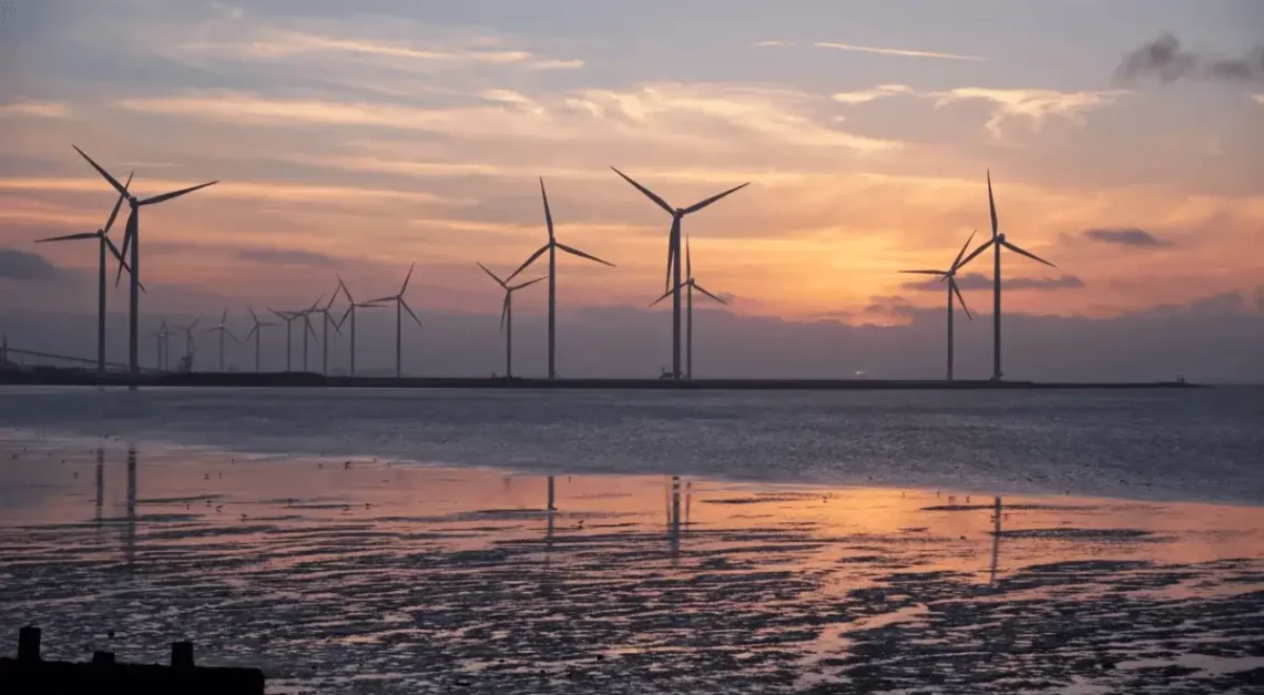 Wind turbines on a beach in the evening, harnessing renewable energy sources.