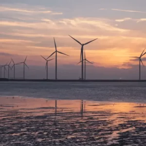 Wind turbines on a beach in the evening, harnessing renewable energy sources.