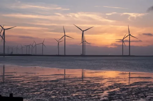 Wind turbines on a beach in the evening, harnessing renewable energy sources.