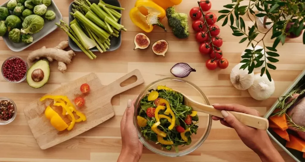Preparation of a fresh vegetable salad with a variety of colorful ingredients.
