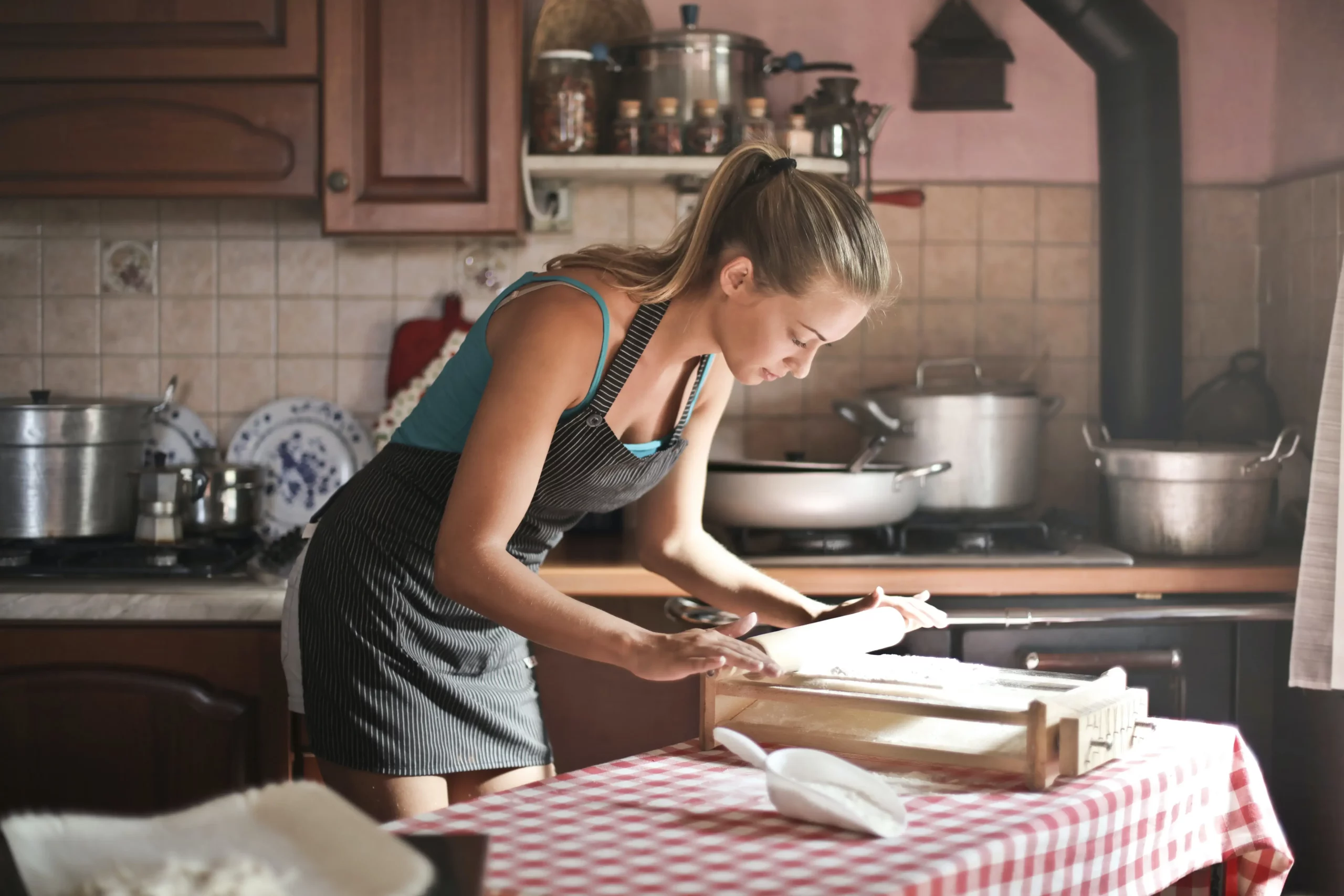 A woman engaged in zero-waste kitchen swaps, skillfully preparing a meal in her kitchen.